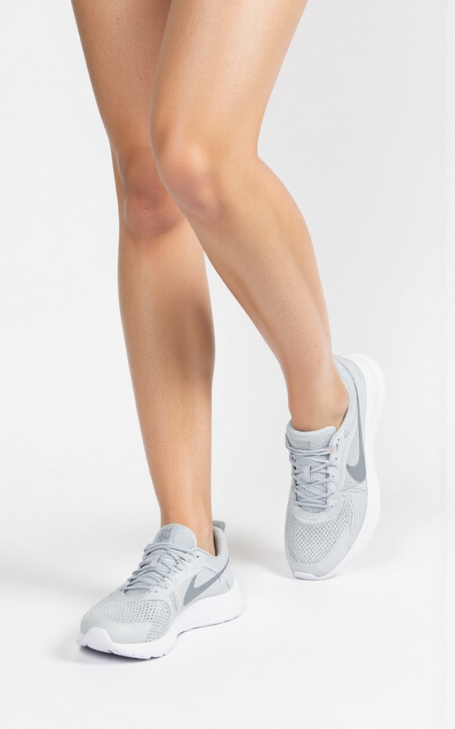 A female model wearing tennis shoes, against a white background, with a close   up of the feet